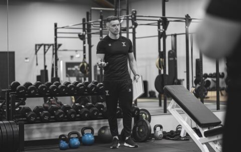 a-photo-of-a-sports-coach-in-a-gym-the-coach-is-st-YuQYKmxbT12AEpKfRbj_mg-kF6H8IZTQHKCnnFnXzwW3g
